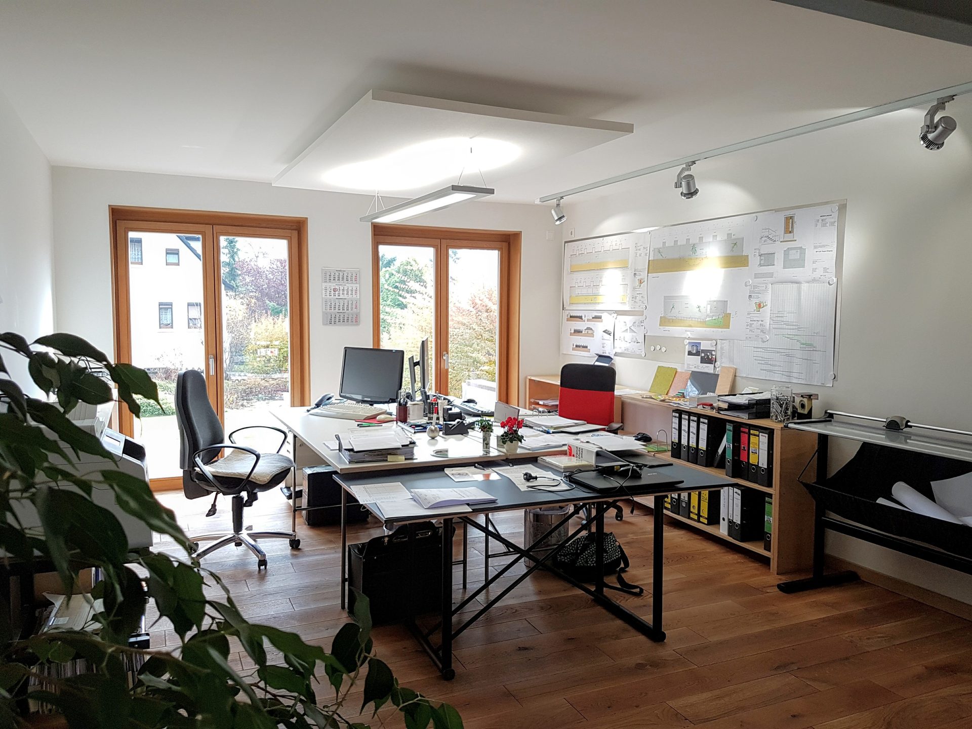 Heller Arbeitsraum im Büro am Weberweg mit Zeichentisch, Planwand und Blick in den Garten (Wilthen)