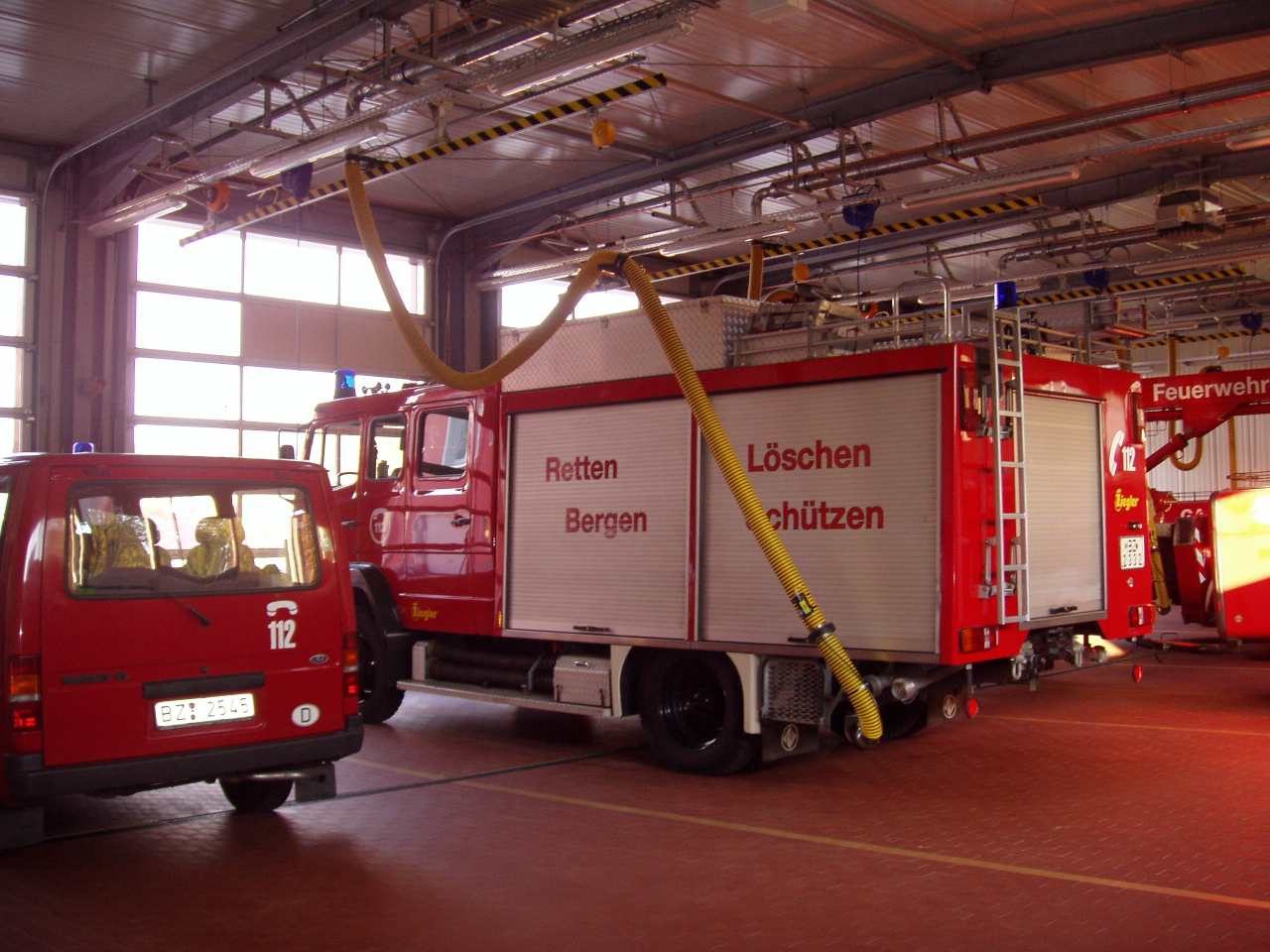 Einsatzfahrzeuge in der hell belichteten Fahrzeughalle