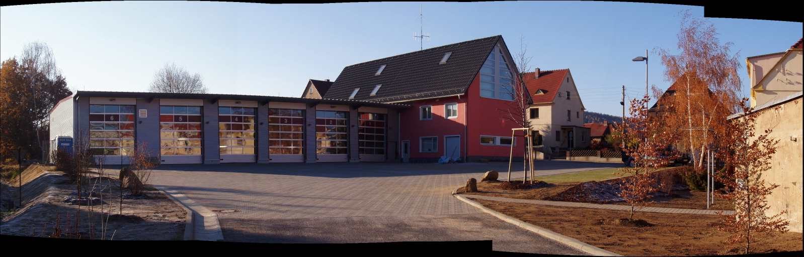 Gesamtanlage des Feuerwehrgerätehauses mit Fahrzeughalle und Übungsfläche im Panorama