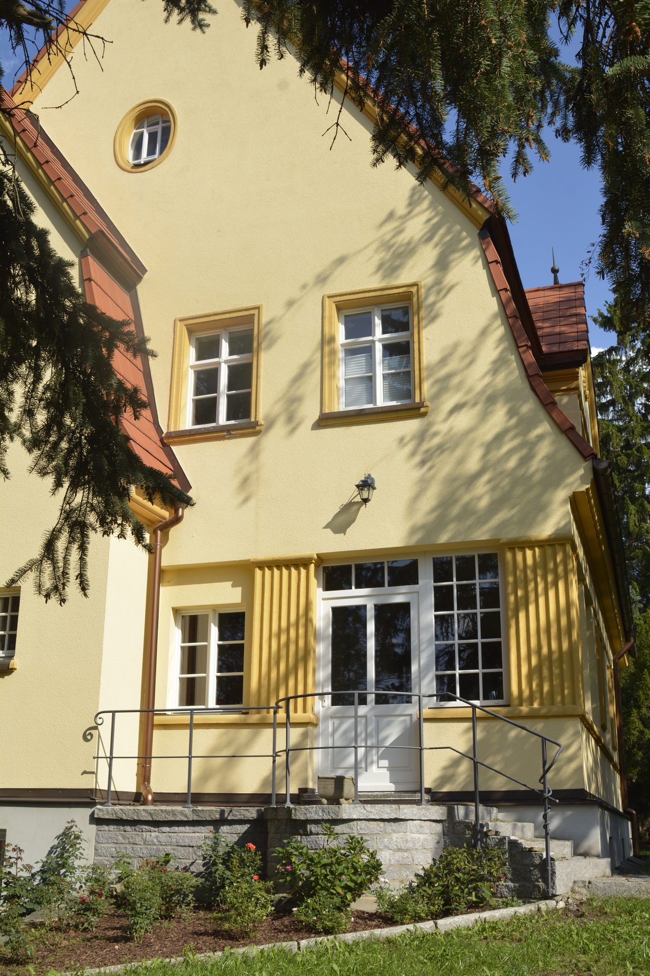 Giebelseite der Villa mit verglastem Vorbau und Sprossenfenstern