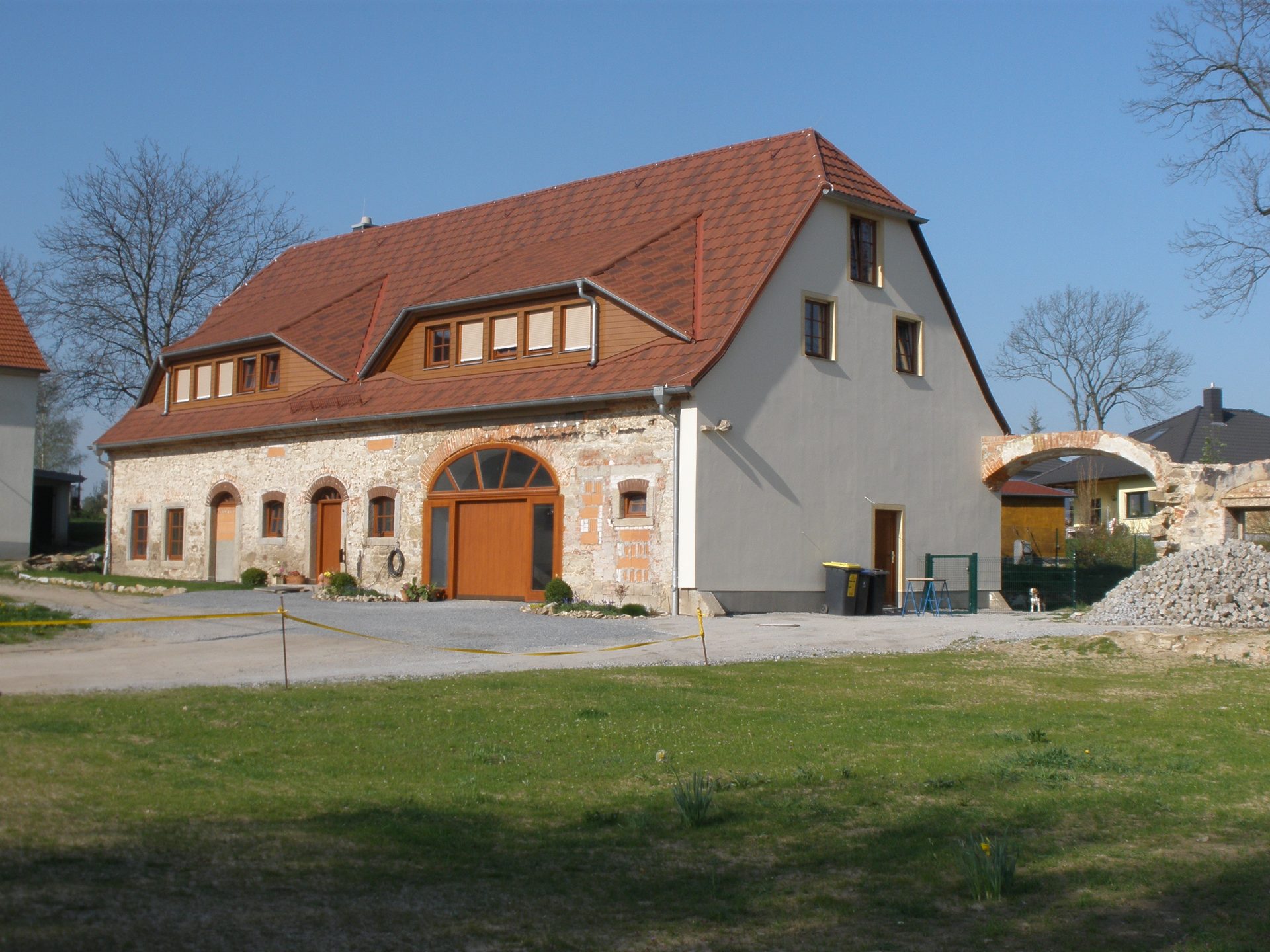 Saniertes Rittergutsgebäude in Stiebitz mit rotem Ziegeldach und rundbogigem Tor