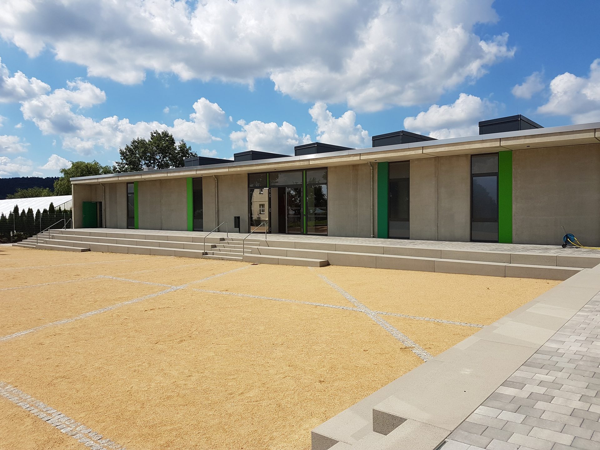 Neu geschaffene Piazza als Treffpunkt zwischen neuer Sporthalle und denkmalgeschützter alter Turnhalle
