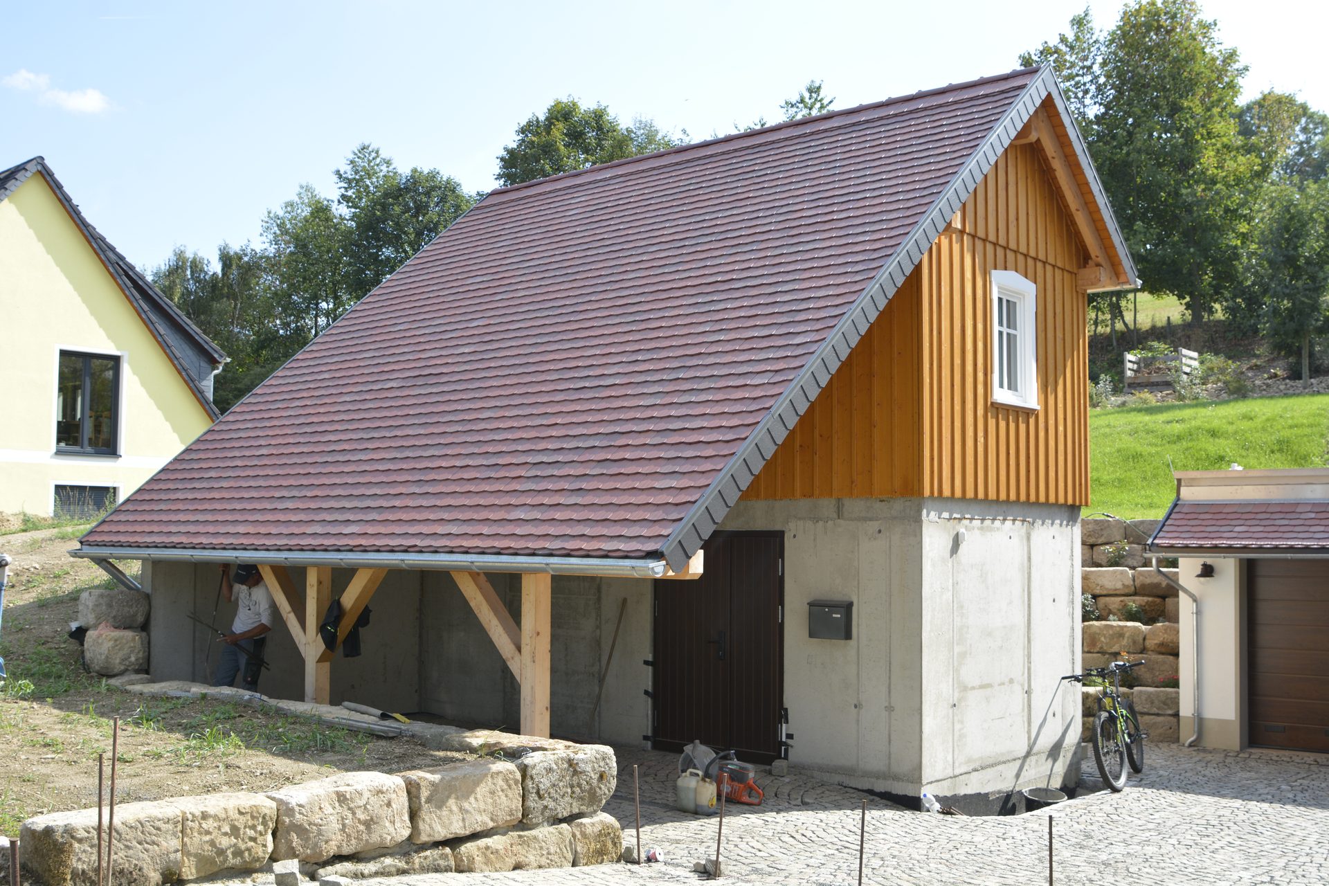 Nebengebäude mit Holzgiebel und massiver unterer Ebene am Hang